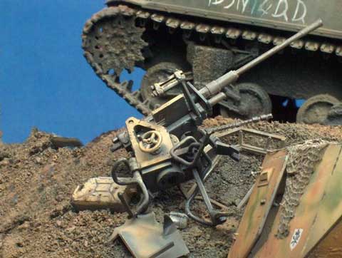 Diorama a escala 1/35 de un Sherman en combate pasando al lado de restos de otros vehiculos.