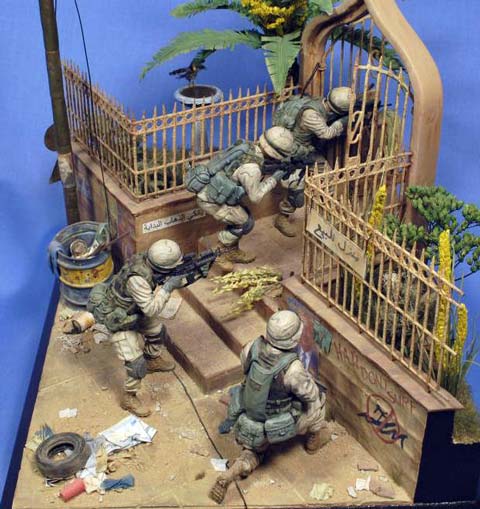 Magnífica viñeta/diorama ambientada en Irak de un grupo de soldados peinando una calle casa por casa en busca de terroristas o insurgentes. 