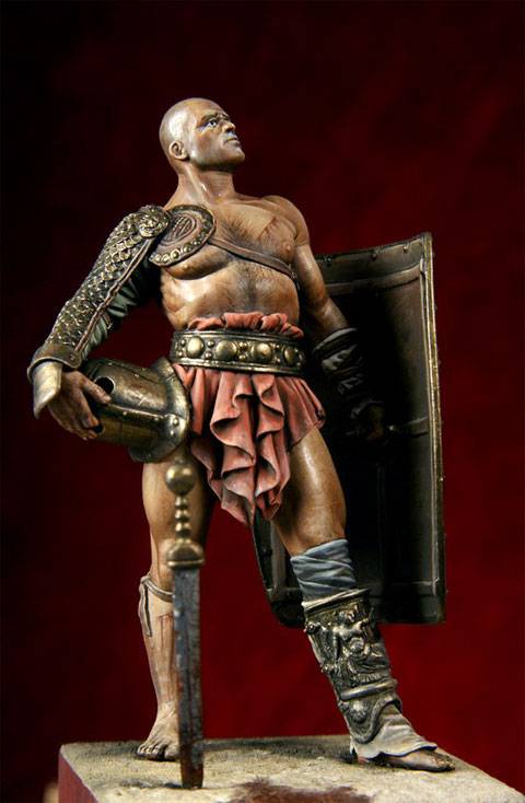 figura de un Gladiador en posición de descanso después de haber ganado un combate, mirando hacia el  público que llena el aforo en actitud desafiante.