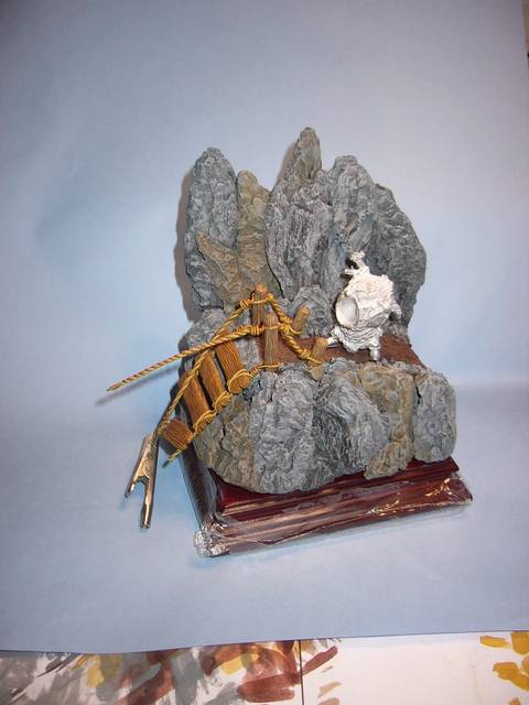 Pequeño Diorama o viñeta con un puente colgante roto situado en lo alto de un acantilado
